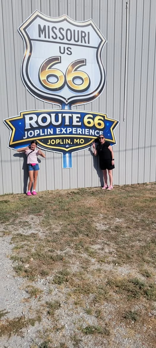 Visitors posing beside the museum's Route 66 sign